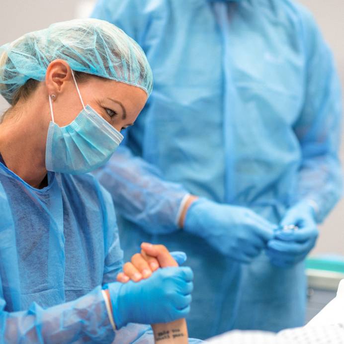 Surgeon holds the hand of a patient